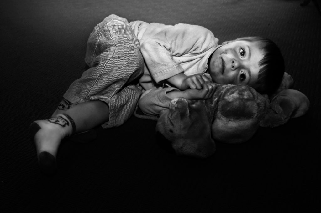 Photo of a grubby child lying on the ground with a toy. If a SAR team is affiliated with Law Enforcement, they are what's called "mandatory reporters," if child abuse is suspected. Photo © Photobunnyuk | Dreamstime.com