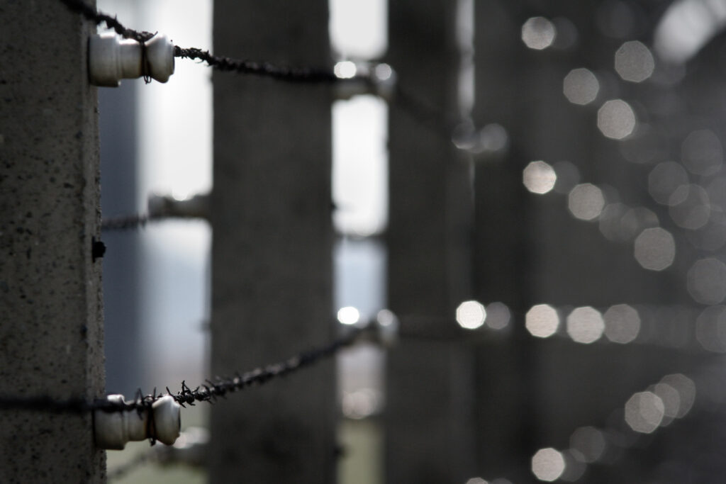 Photo of barbed wire around a prison. A former Bureau of Prisons (BOP) Corrections Officer was sentenced to 42 months in prison and three years supervised release for sexually assaulting two women.