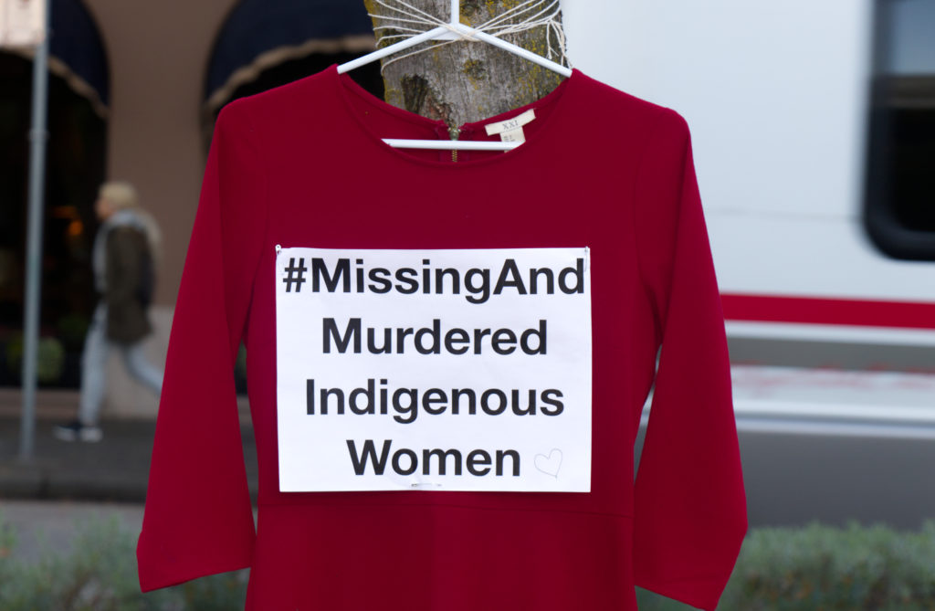 A red dress with the text "Missing And Murdered Indigenous Women" hangs at a Vancouver art memorial to honor Missing and Murdered Indigenous Women in the U.S. and Canada.