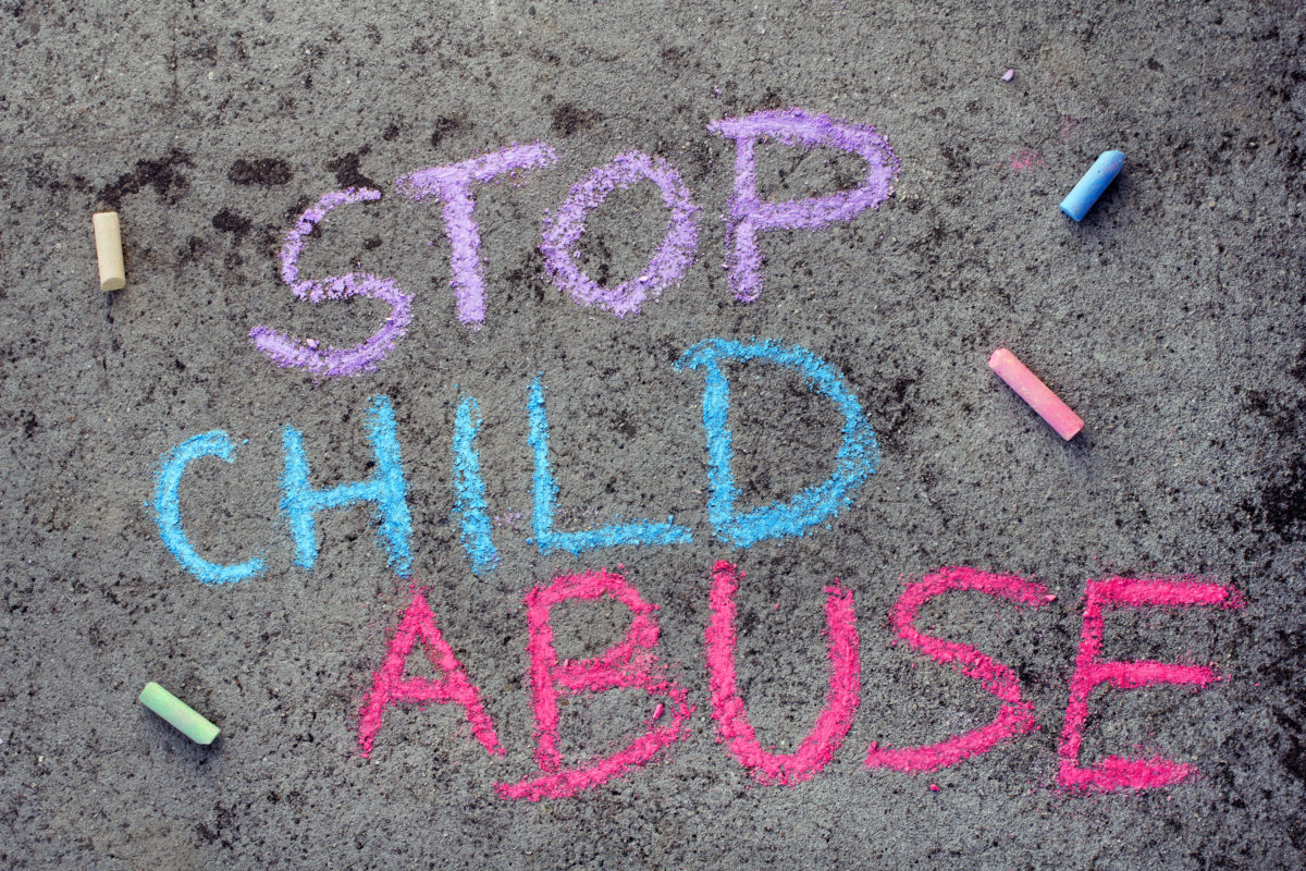 Photo of a sign that reads stop child abuse