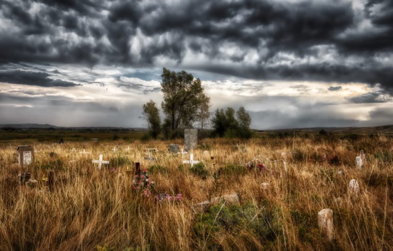 Representative image depicting a cloudy sky over the Shoshone Tribal Cemetery in Wyoming