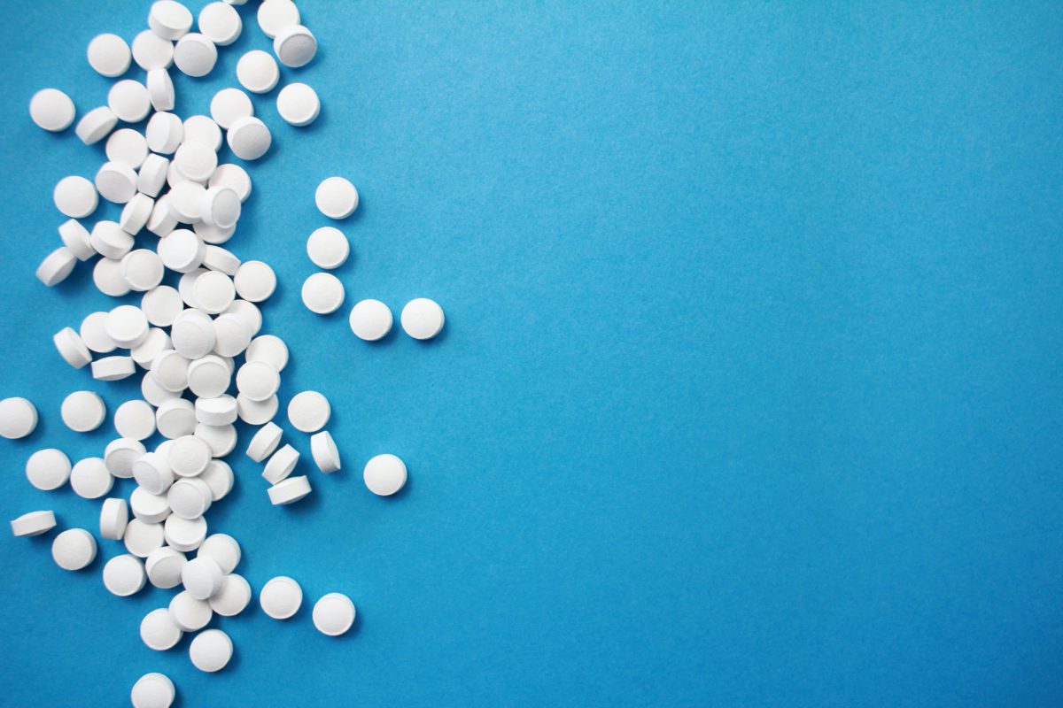 Representative image of round, white pills against a blue background