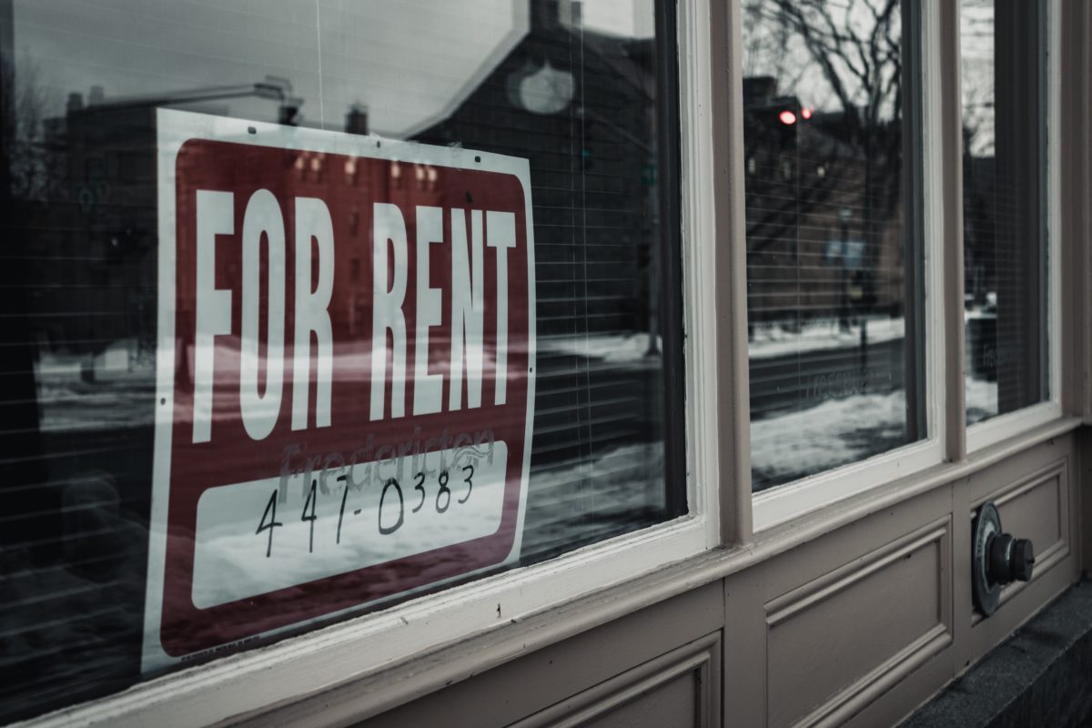 Photo depicting a "for rent" sign in a window