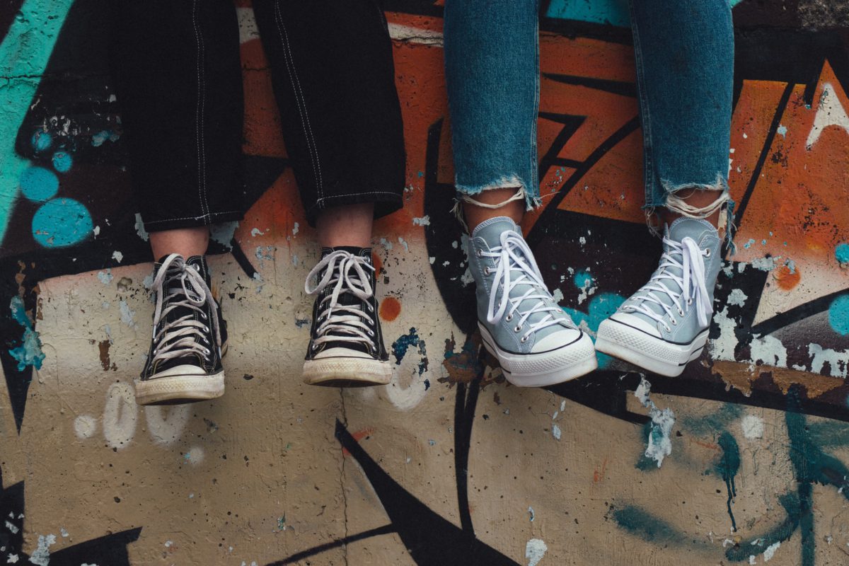 Representative photo of youth displayed sitting on a graffiti-filled street | Photo by Aedrian on Unsplash