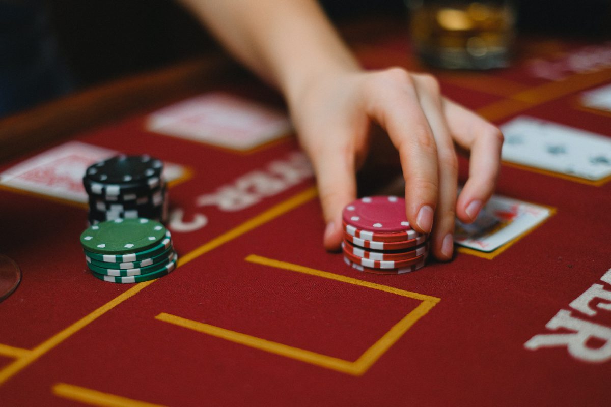Image of a hand placing poker chips on a card table
