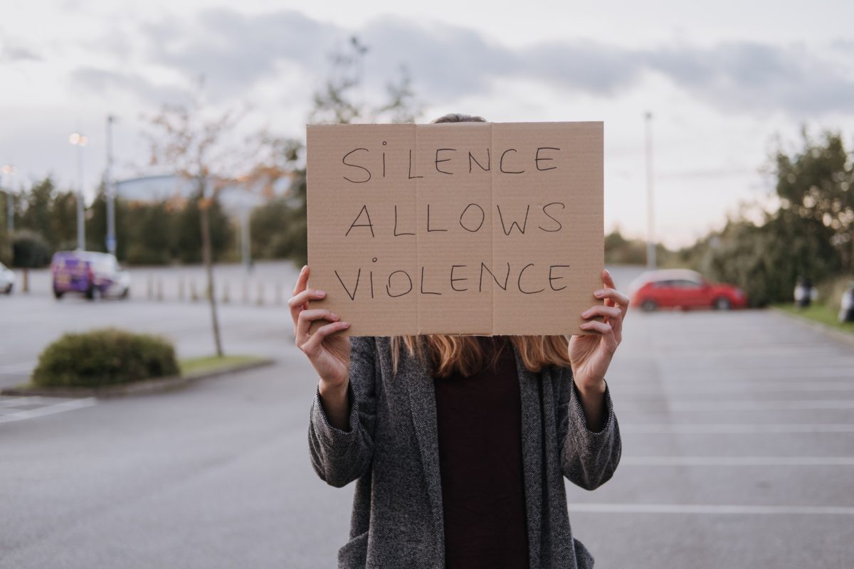 Representative photo of a woman holding a placard that says "Silence allows violence" | Photo by Anete Lusina from Pexels