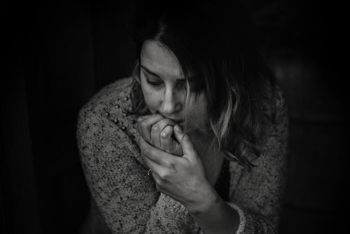 Photo of a woman looking worried and biting at her fingernails