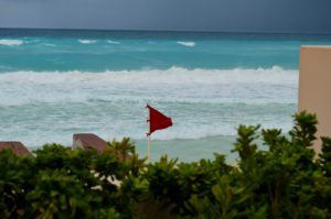 Image of a red flag waving on a beach