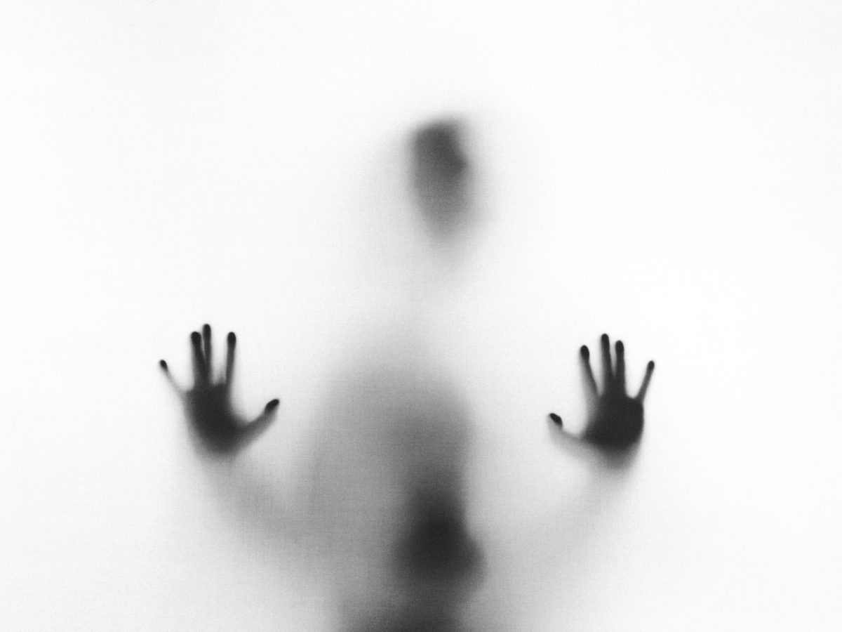Representative photo of a person standing behind a glass door with their hands pressed against it | Photo by Stefano Pollio on Unsplash