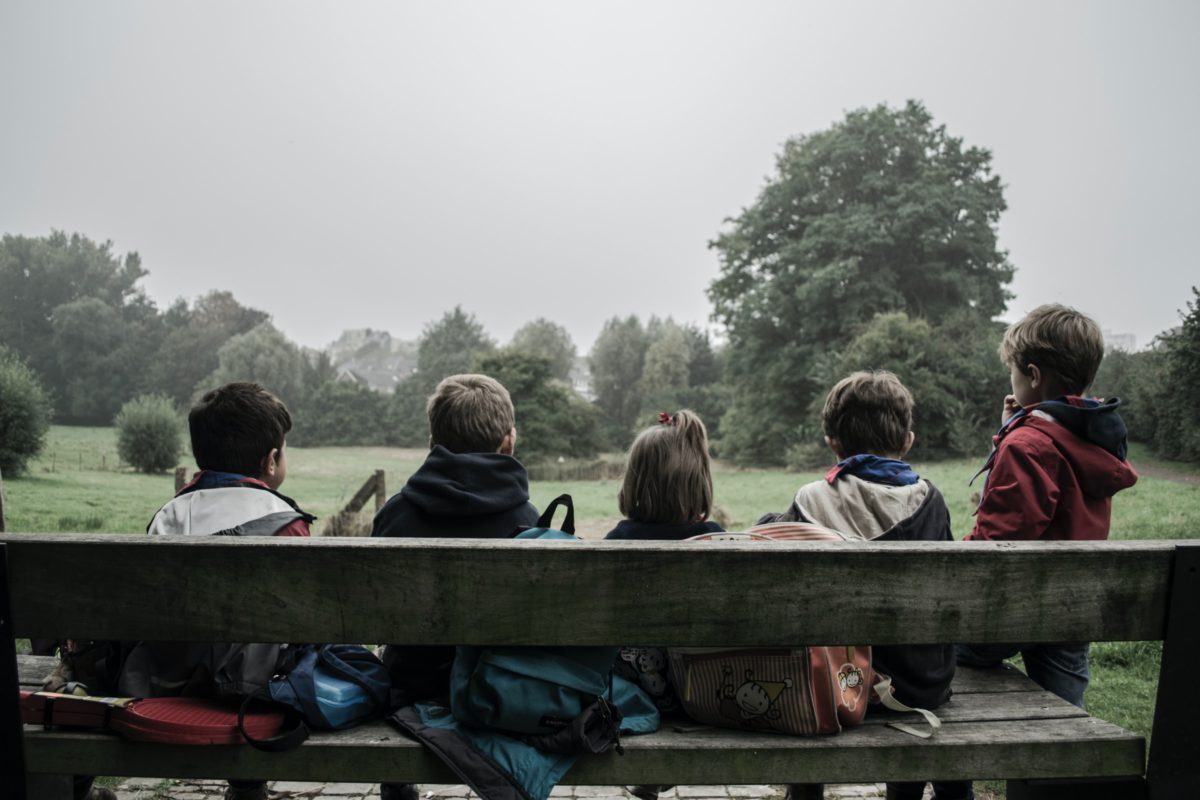 Children sitting on a bench at a park | Photo by Piron Guillaume on Unsplash
