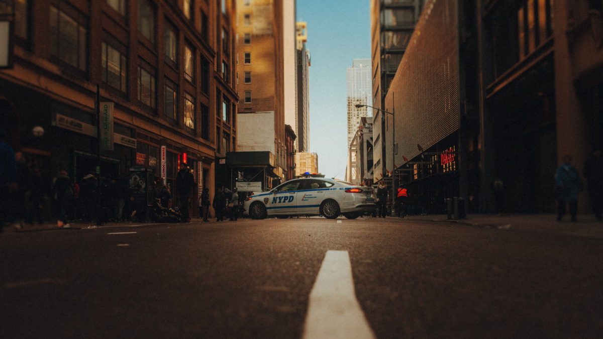 A police car parked on the side of the road, shot in low light | Photo by Josh Couch on Unsplash