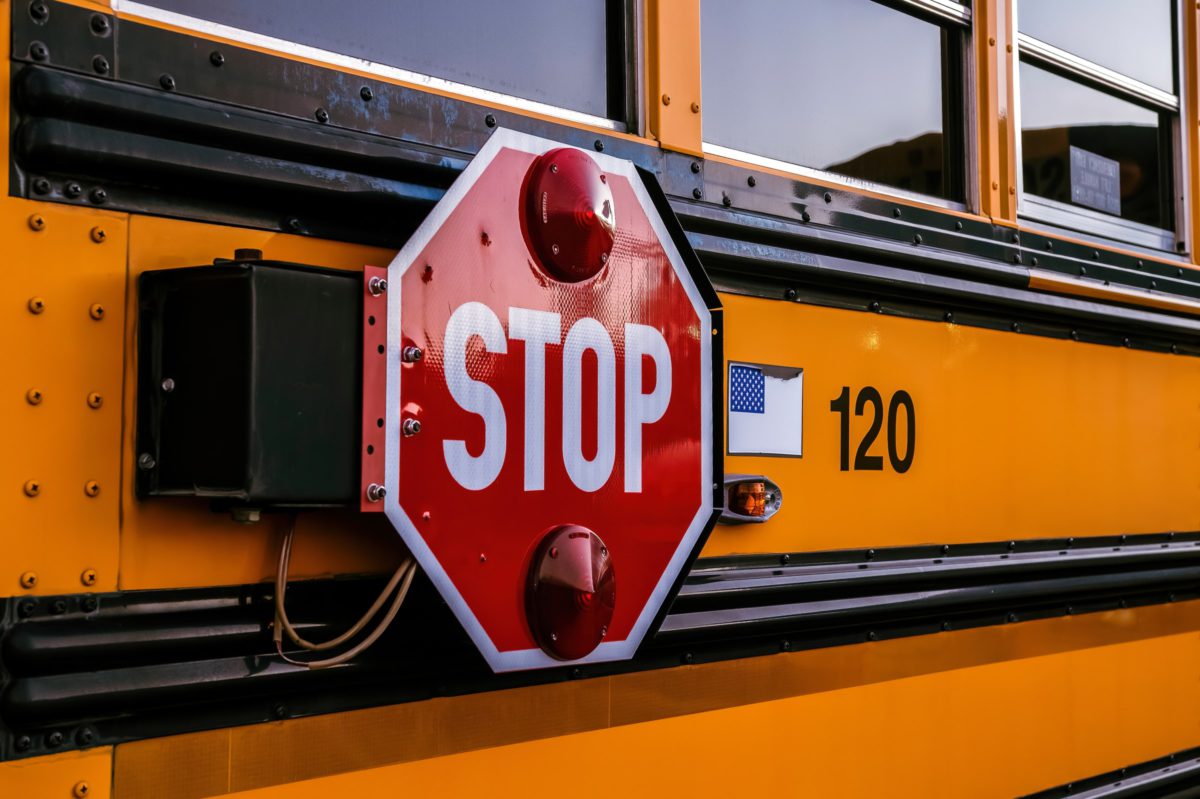 A safety "Stop" sign seen on a school bus | Photo by Robin Jonathan Deutsch on Unsplash
